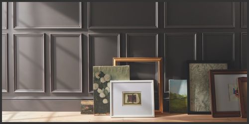 Framed artworks against a dark paneled wall. Benjamin Moore 2026 Color of the year Silhouette AF-655