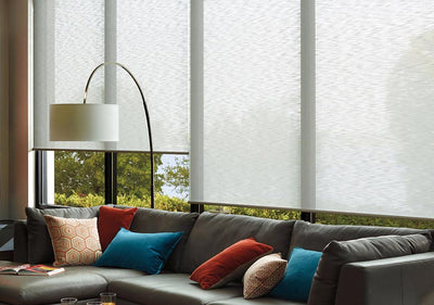 A living room with three large windows displaying Hunter Douglas Alustra Woven Textures in white, available at Gleco Paint in PA.